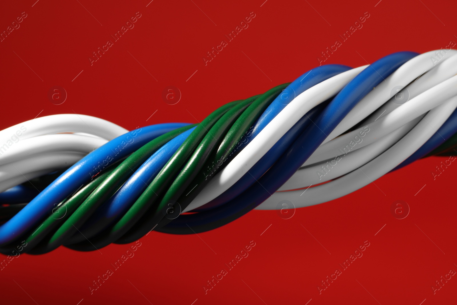 Photo of Electrical wires on red background, closeup view