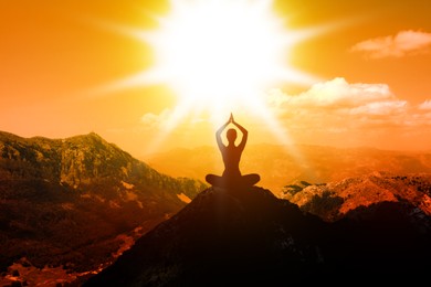 Image of Woman meditating in mountains at sunset, back view