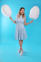 Photo of Full length portrait of pretty young woman with tasty cotton candy on blue background