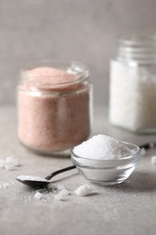 Photo of Different natural salt on grey table, closeup