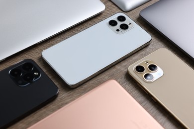 Photo of Many different modern gadgets on wooden table