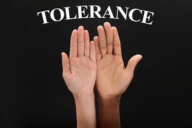 Image of Tolerance concept. Woman and man of different races showing hands on black background, closeup
