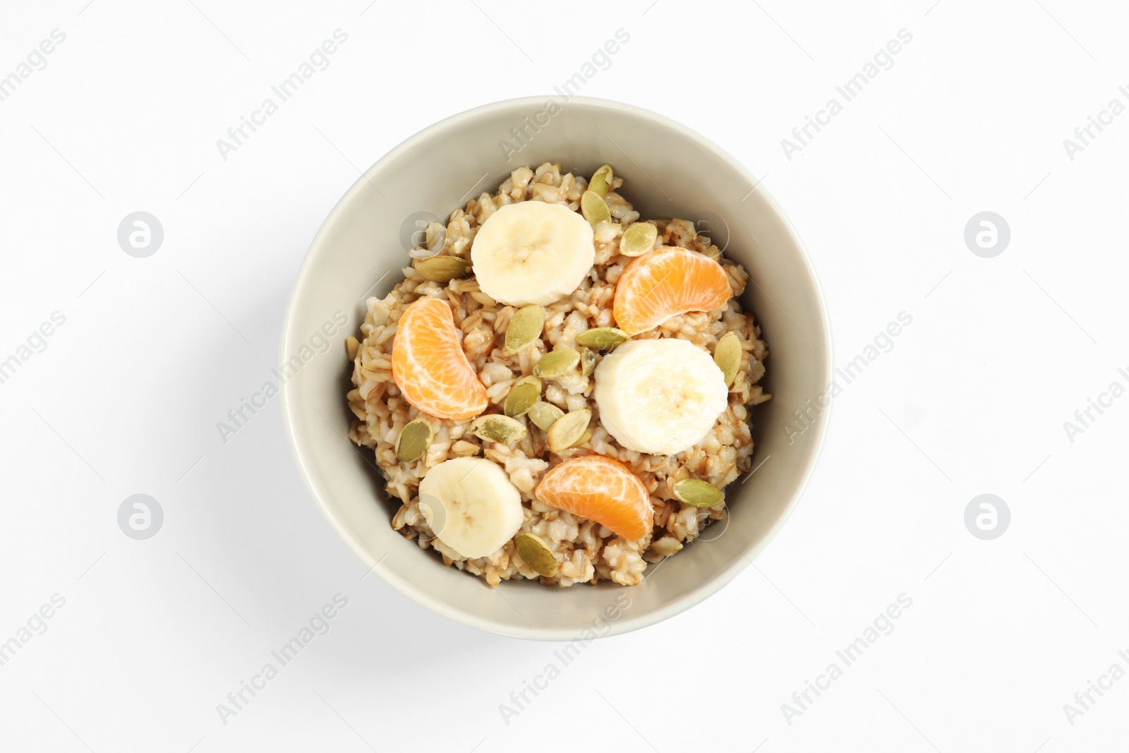 Photo of Tasty oatmeal with fruits and pumpkin seeds isolated on white, top view. Healthy breakfast