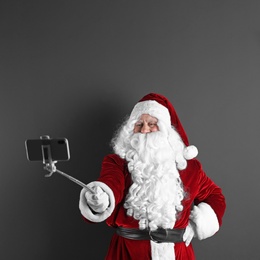 Photo of Authentic Santa Claus taking selfie on grey background