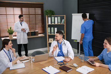 Photo of Team of professional doctors having meeting in office