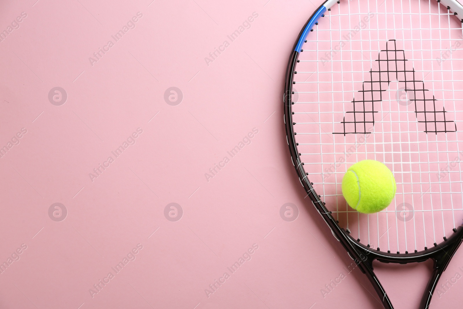 Photo of Tennis racket and ball on pink background, top view. Space for text