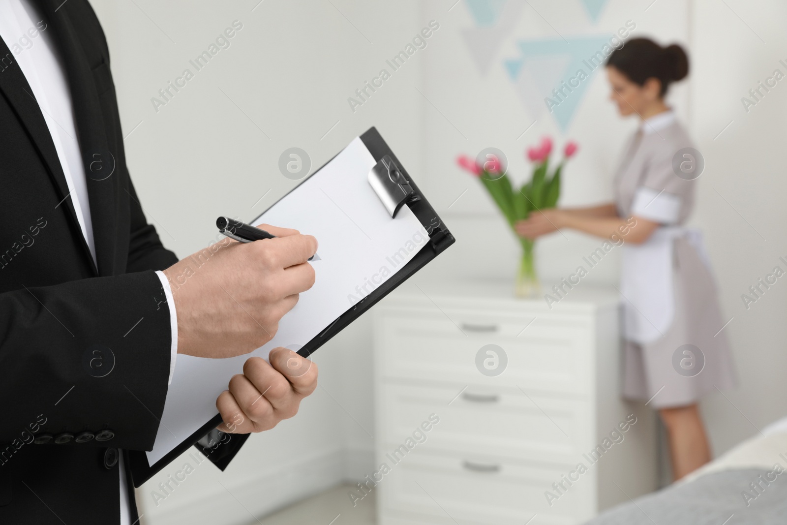 Photo of Housekeeping manager checking maid work in hotel room, closeup