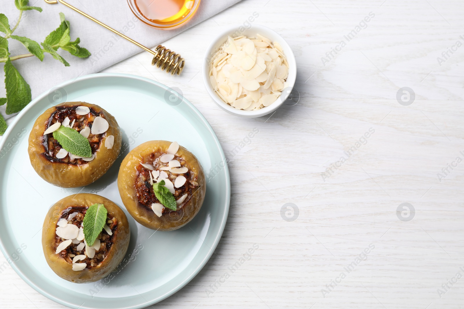 Photo of Baked apples on white wooden table, flat lay. Space for text