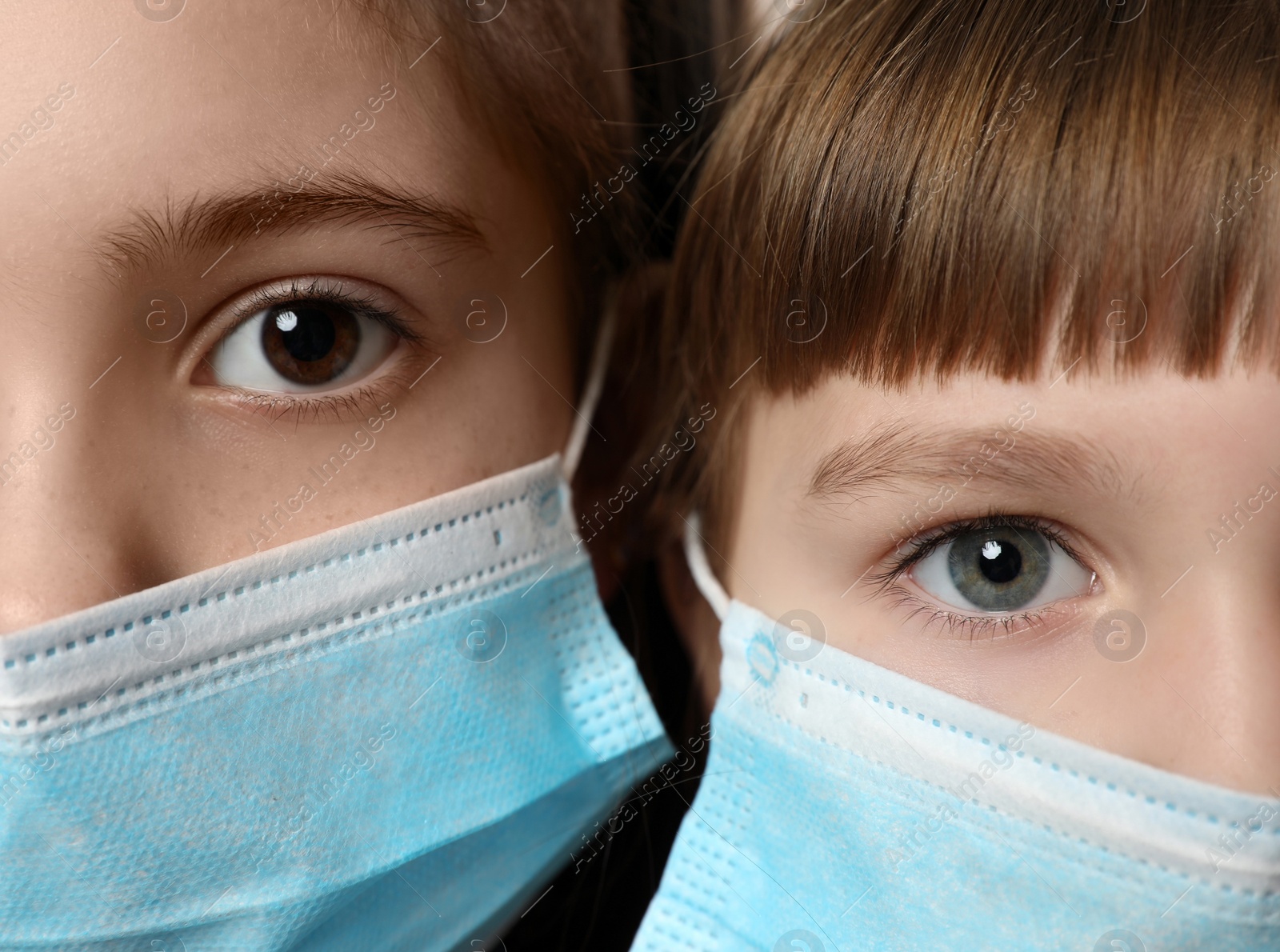 Photo of Little girls in medical masks, closeup. Virus protection