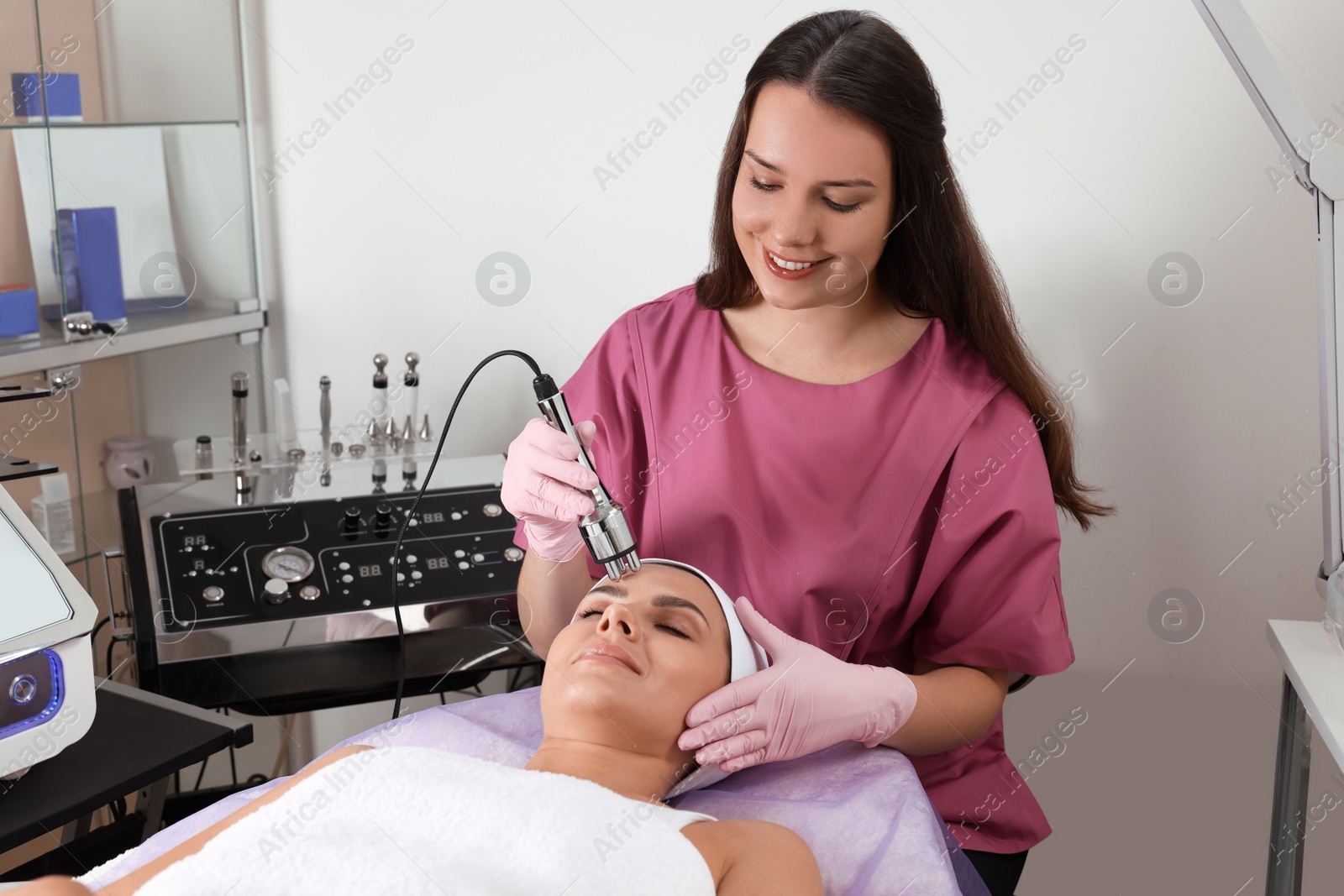 Photo of Young woman undergoing cosmetic procedure in beauty salon. Microcurrent therapy