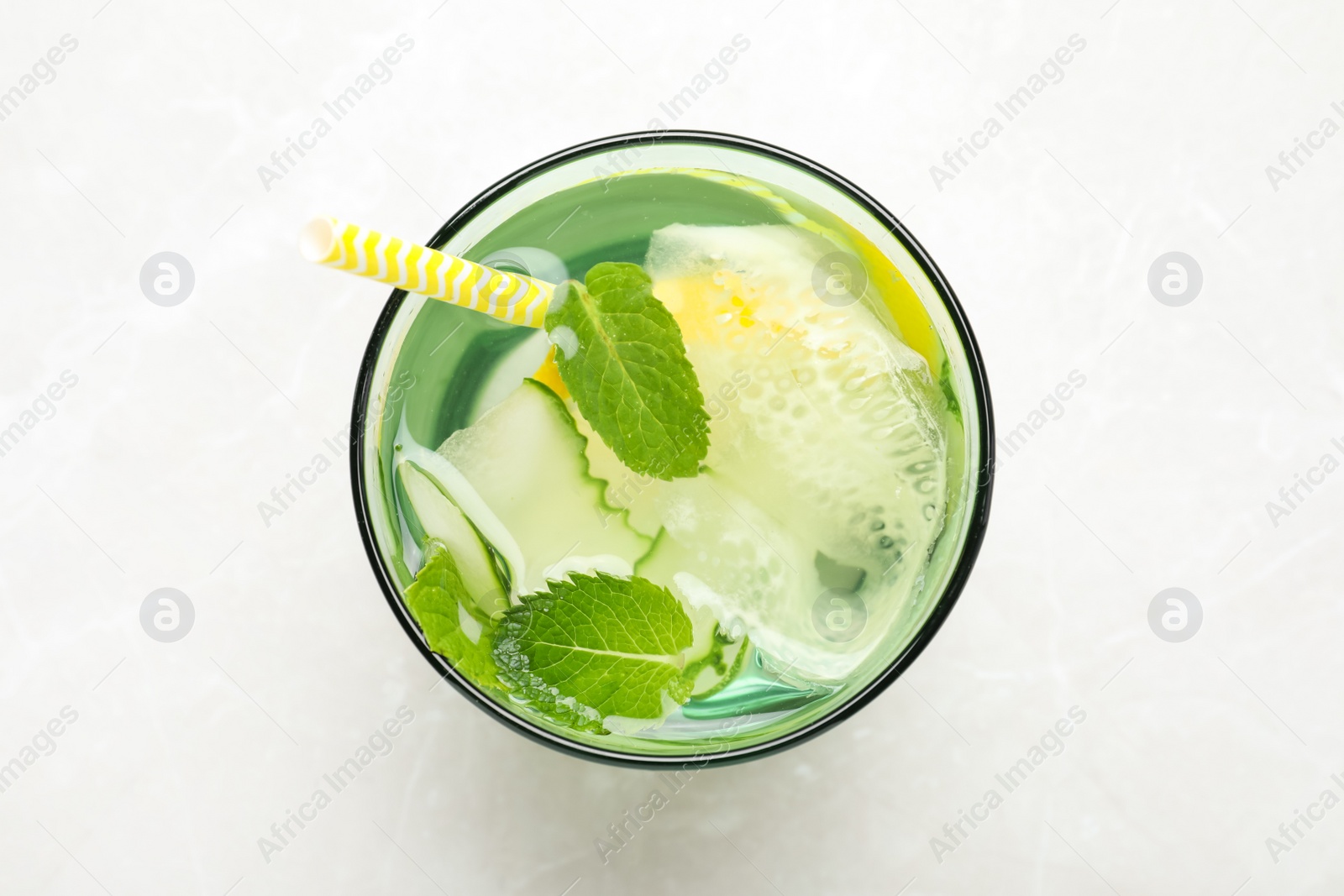 Photo of Refreshing water with cucumber, lemon and mint on white table, top view
