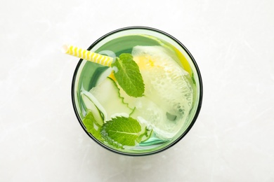 Refreshing water with cucumber, lemon and mint on white table, top view