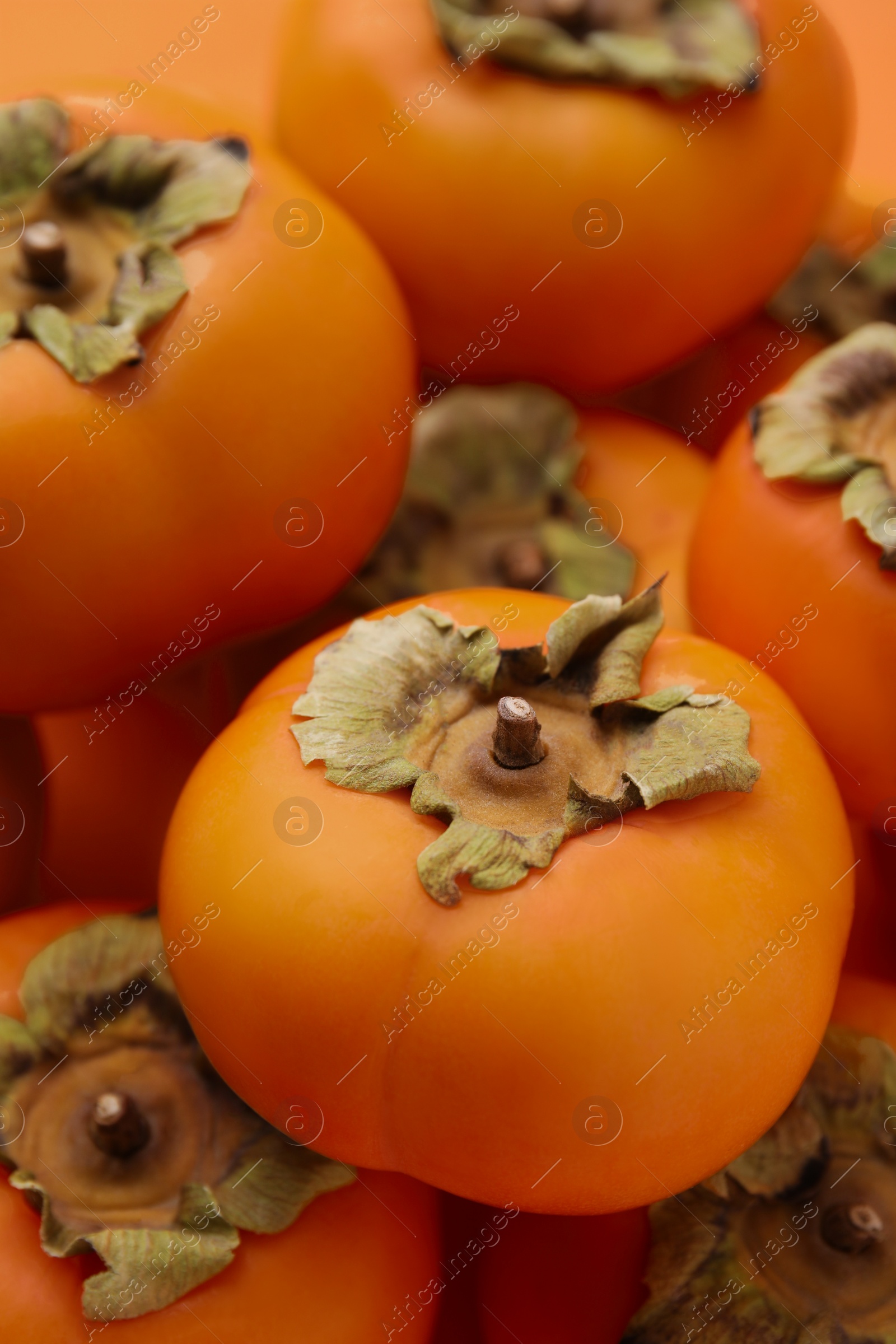 Photo of Delicious ripe juicy persimmons as background, closeup