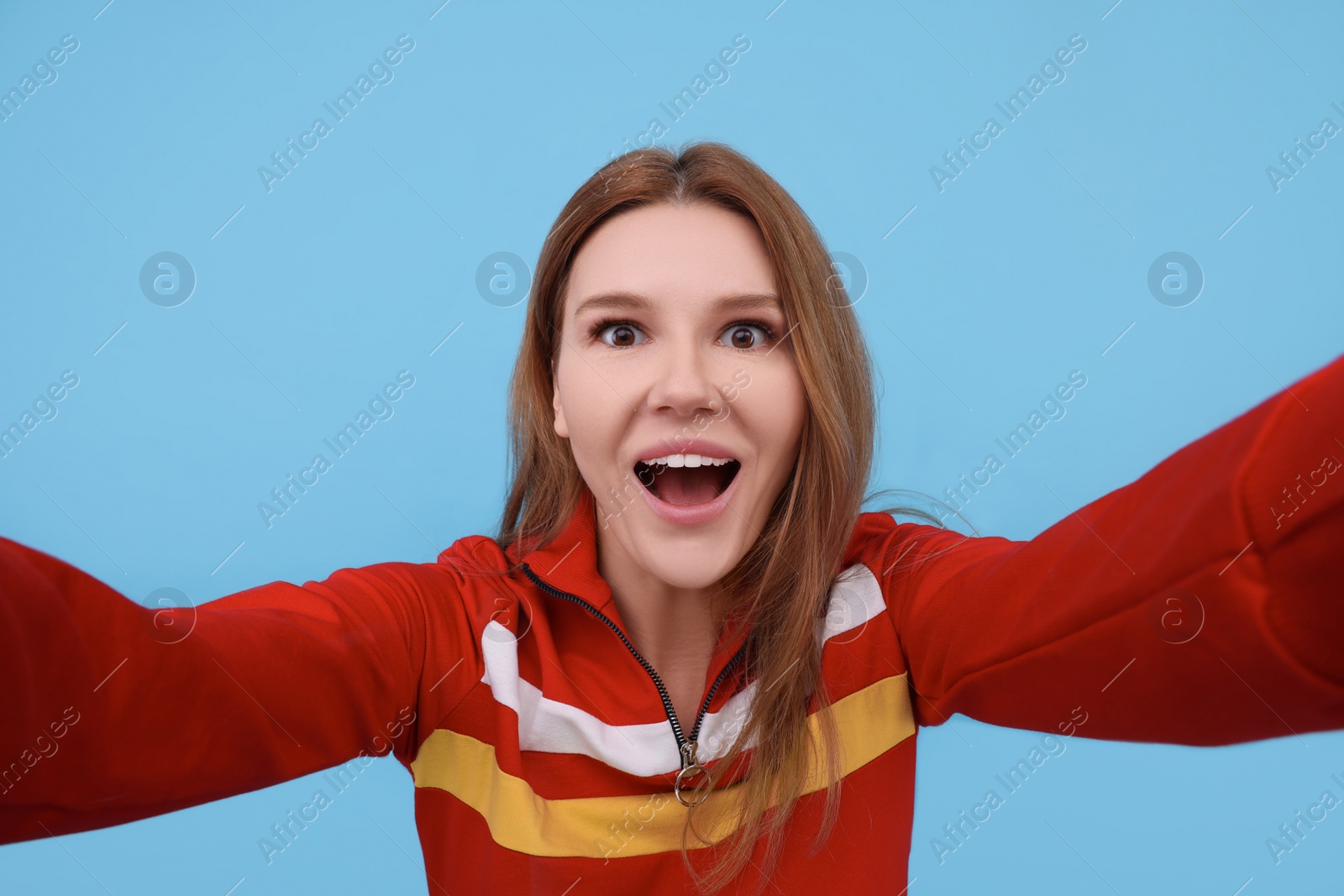 Photo of Beautiful woman taking selfie on light blue background