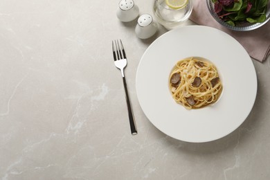 Delicious pasta with truffle slices and cheese served on light grey table, flat lay. Space for text