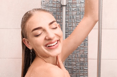 Photo of Beautiful young woman taking shower at home