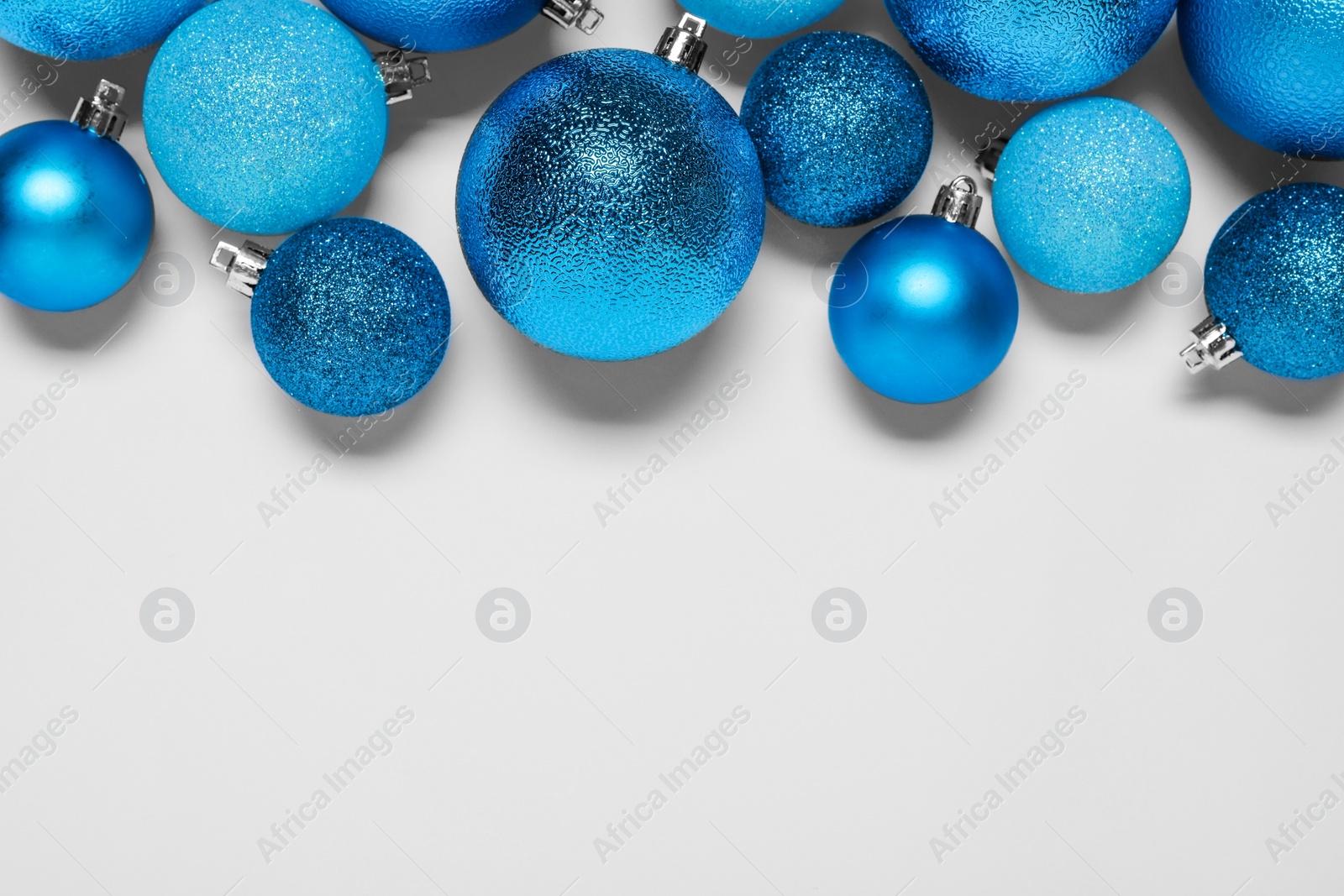 Photo of Light blue Christmas balls on white background, flat lay. Space for text