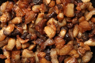 Photo of Tasty fried cracklings as background, top view. Cooked pork lard