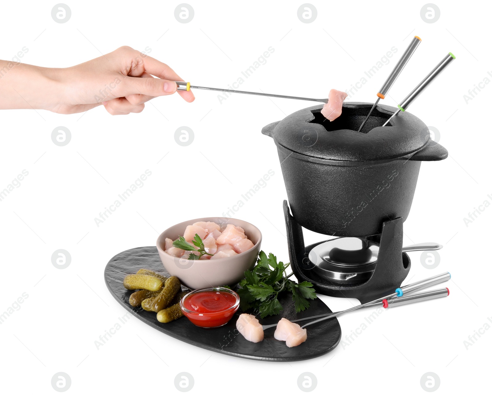 Photo of Woman dipping piece of raw meat into oil in fondue pot on white background