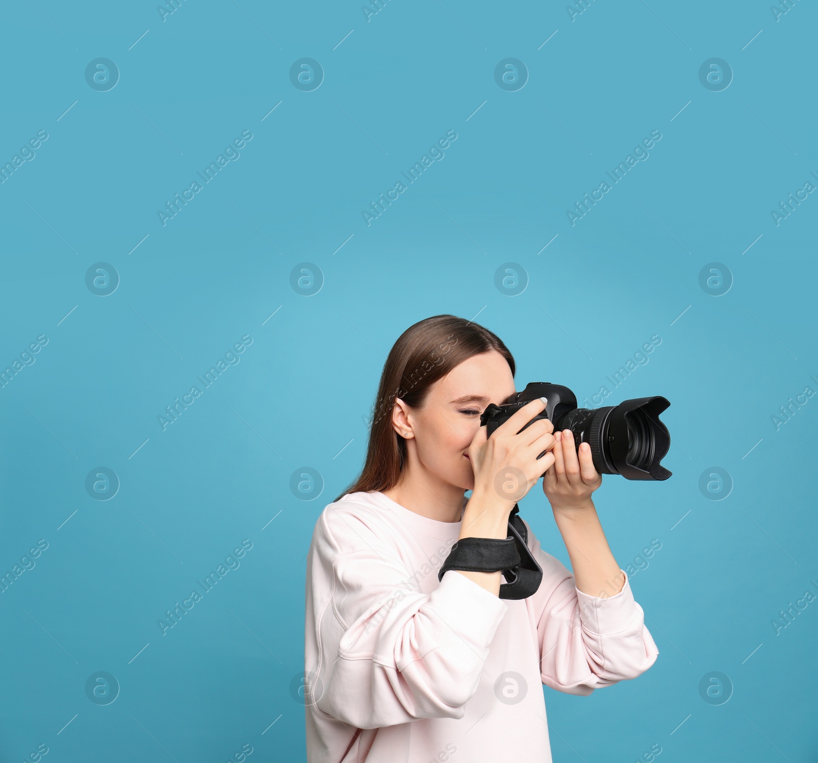 Photo of Professional photographer taking picture on light blue background