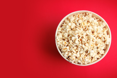 Tasty pop corn on red background, top view. Space for text