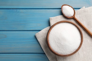 Granulated sugar on turquoise wooden table, flat lay. Space for text