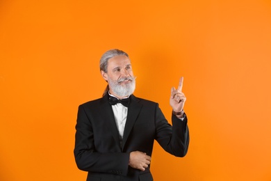 Photo of Handsome bearded mature man in suit on color background