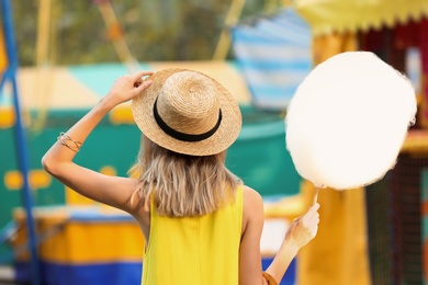 Photo of Young woman with cotton candy in amusement park