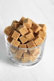 Photo of Brown sugar cubes on white table, closeup