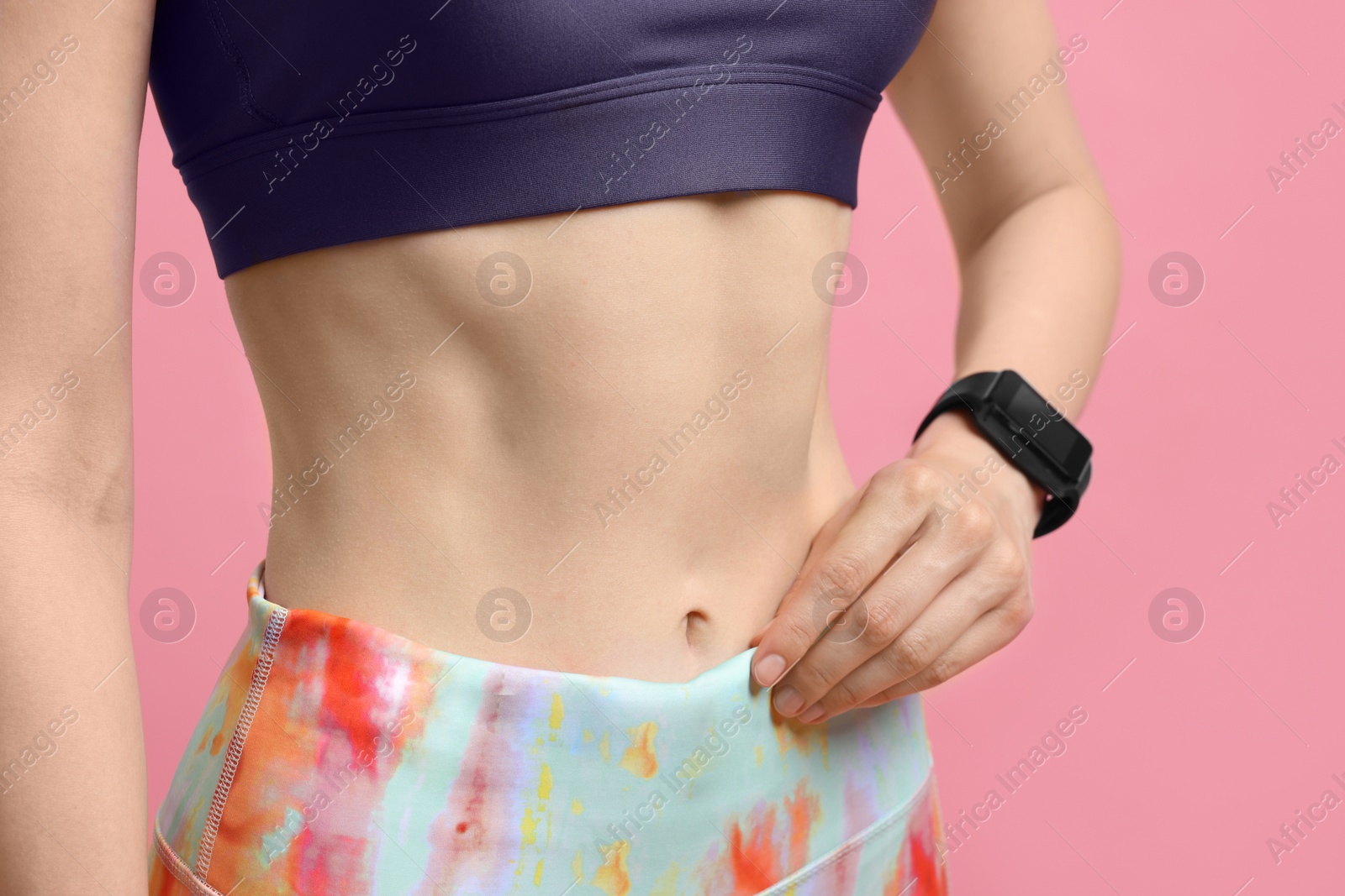 Photo of Woman in sportswear on pink background, closeup