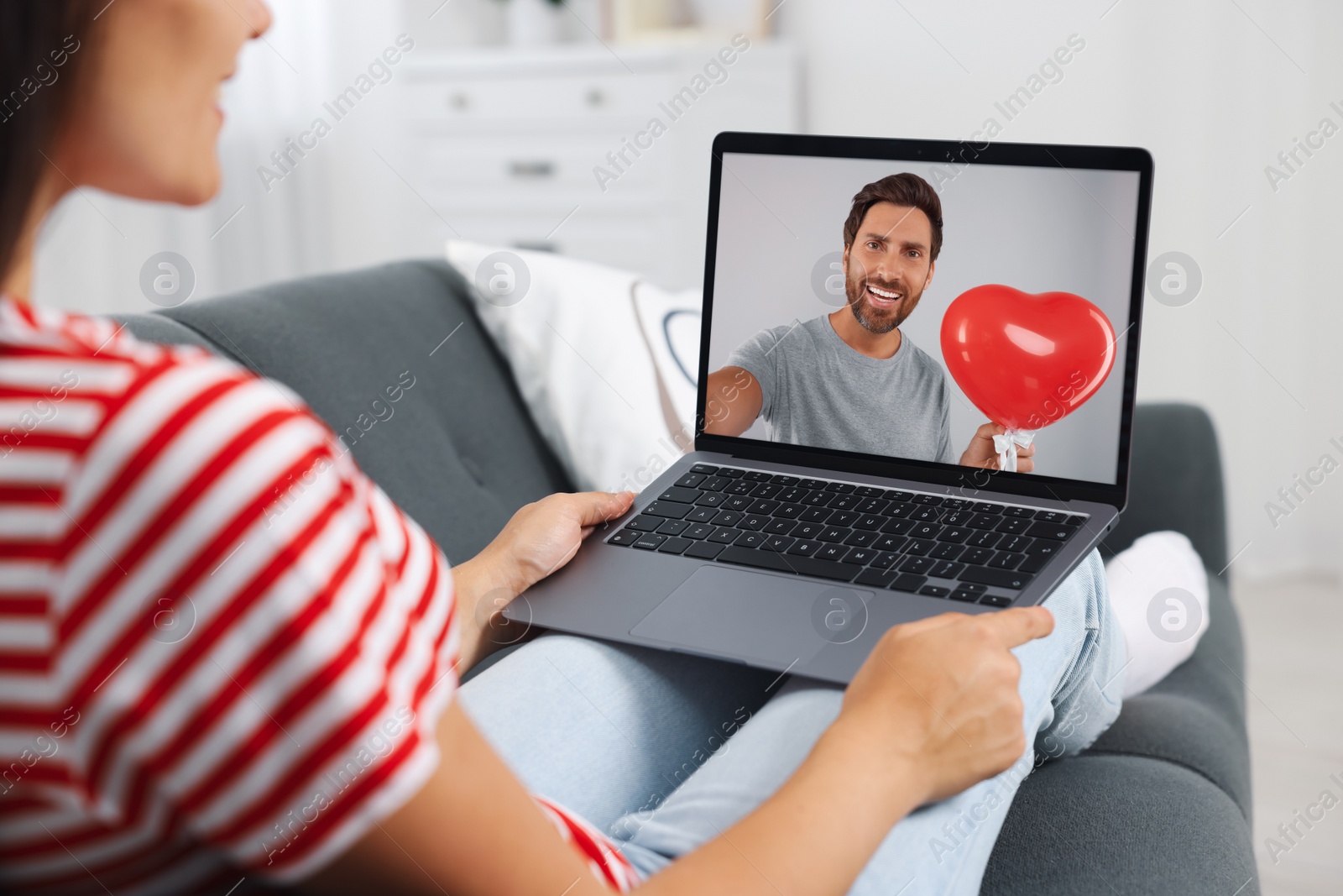 Image of Long distance love. Woman having video chat with her boyfriend via laptop at home, closeup