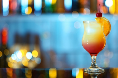 Photo of Glass of fresh alcoholic cocktail on bar counter. Space for text