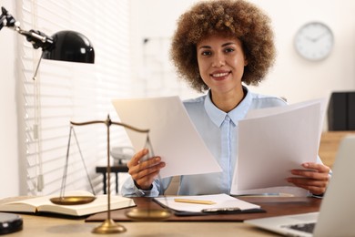 Photo of Happy notary with documents at workplace in office