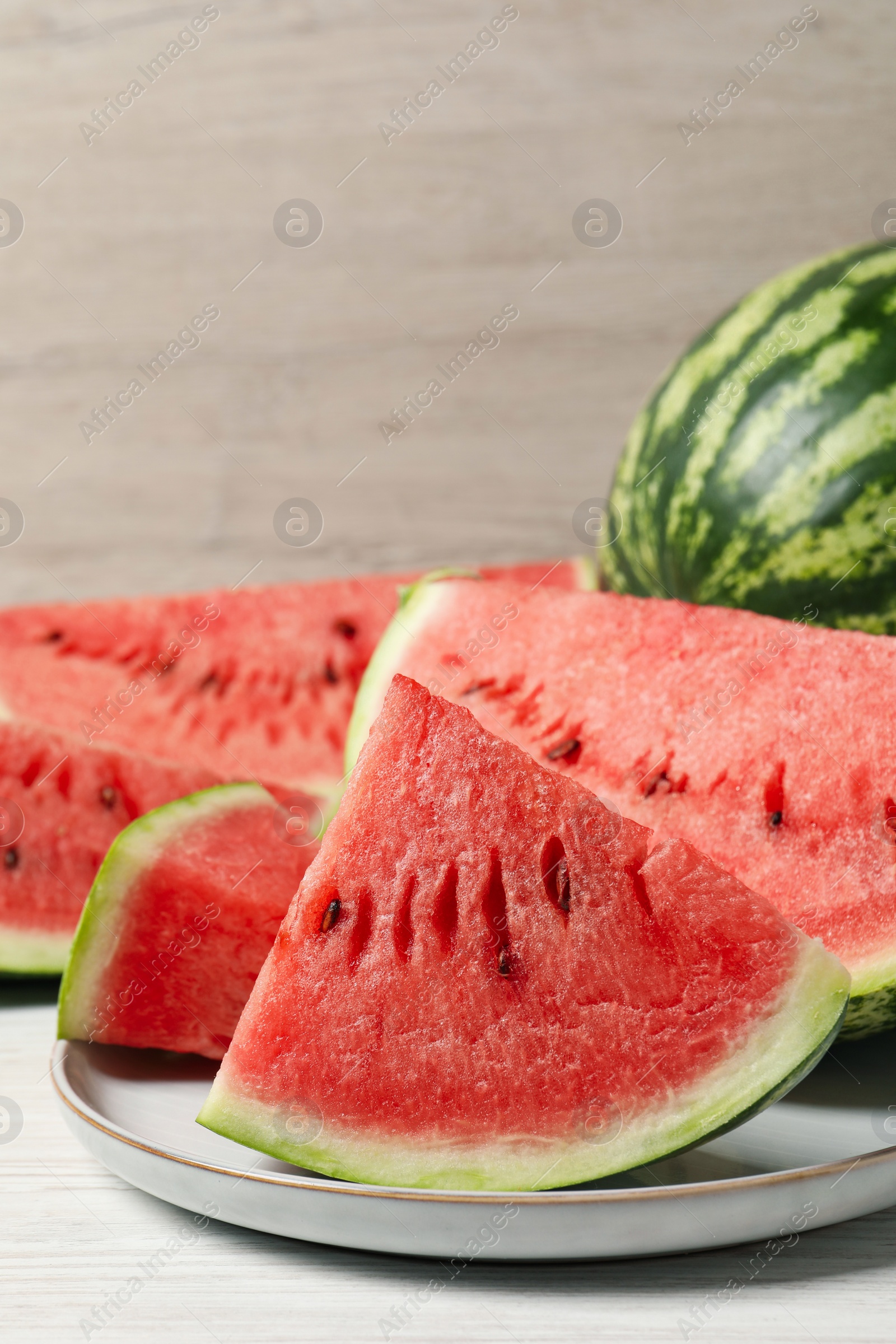 Photo of Tasty ripe watermelons on white wooden table