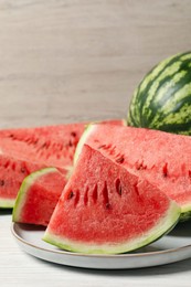 Photo of Tasty ripe watermelons on white wooden table