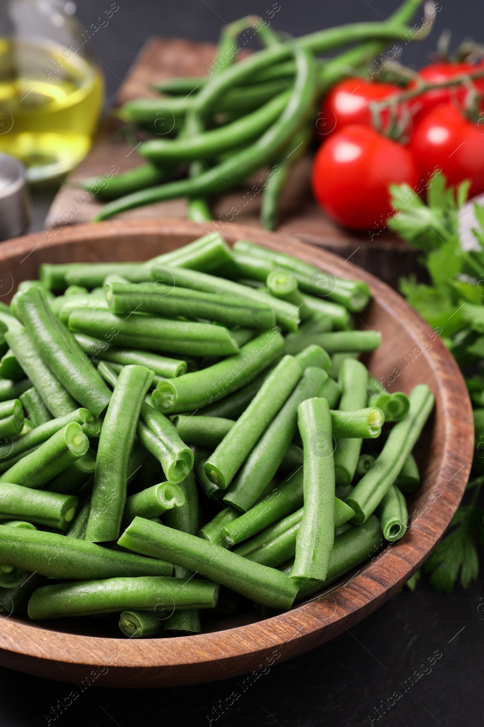 Photo of Fresh raw green beans and other ingredients for salad on table, closeup