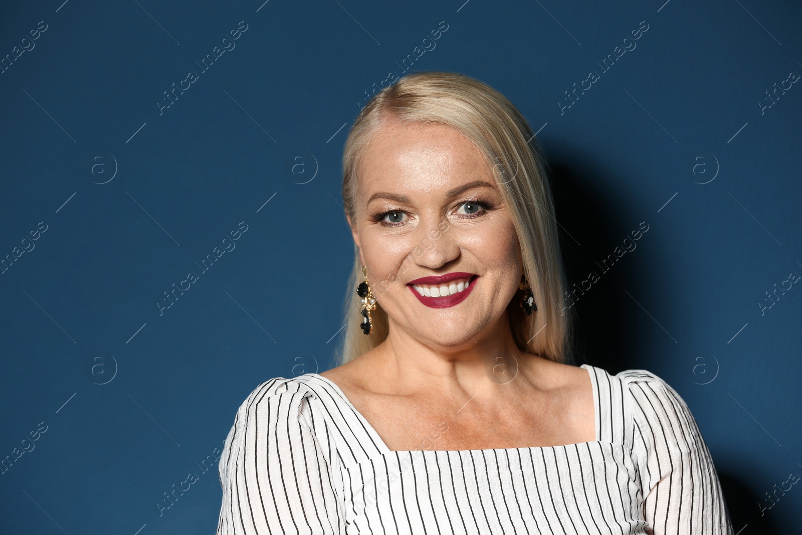 Photo of Portrait of beautiful mature woman on blue background