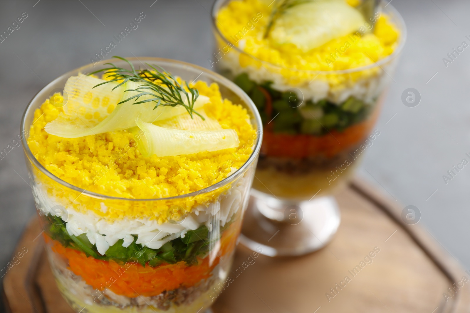 Photo of Traditional russian salad Mimosa on board, closeup. Space for text