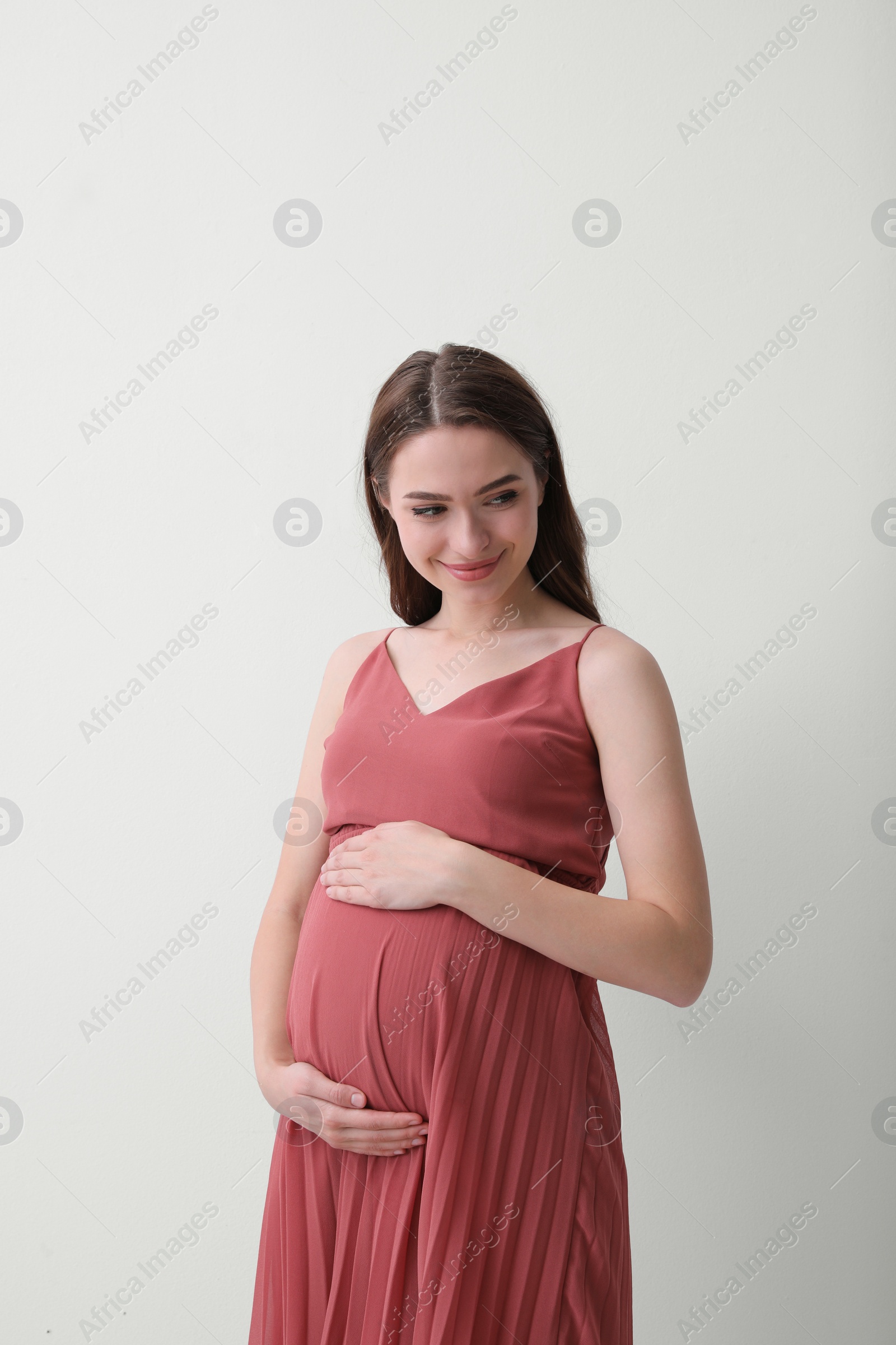 Photo of Beautiful young pregnant woman on light background