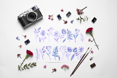 Flat lay composition with floral picture and watercolor paints on white background