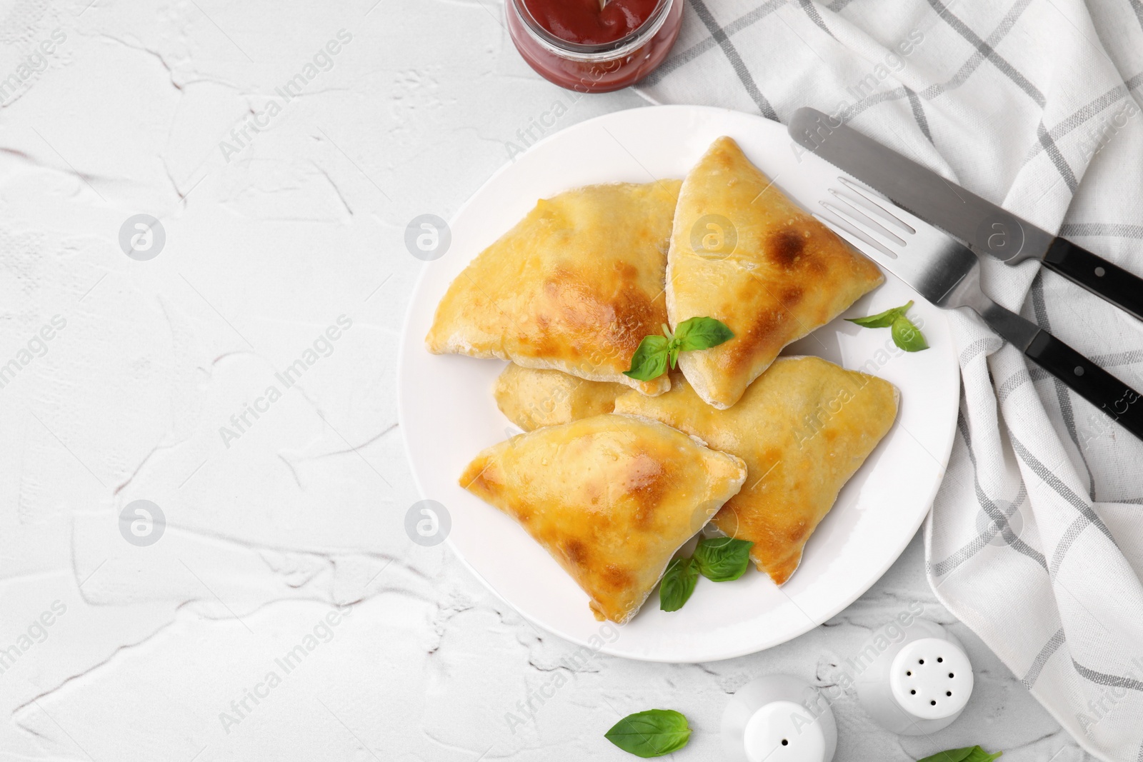 Photo of Delicious samosas served on white textured table, flat lay. Space for text