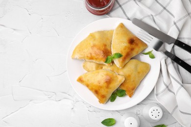 Photo of Delicious samosas served on white textured table, flat lay. Space for text