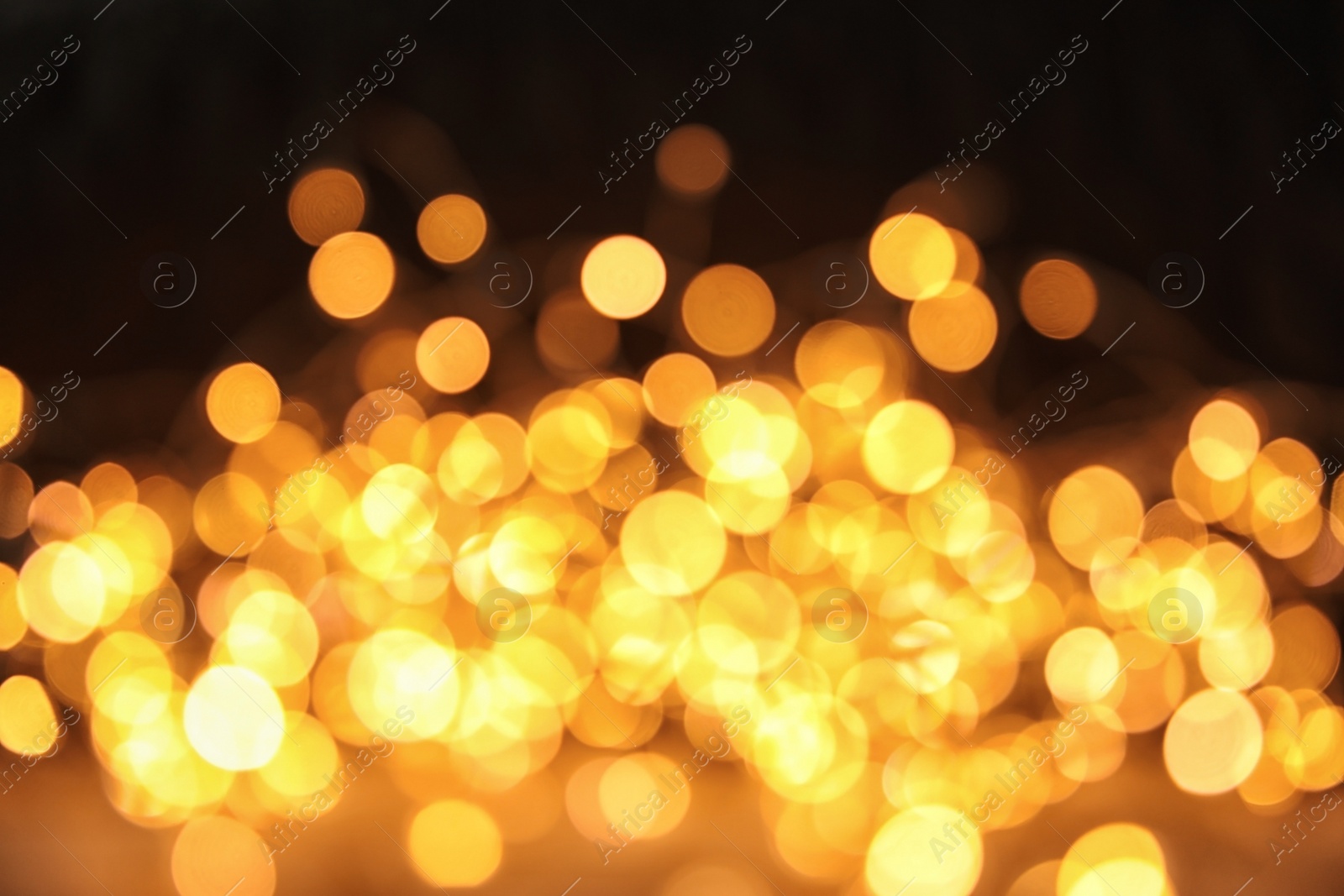 Photo of Gold glitter with bokeh effect on dark background