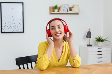 Happy woman in headphones listening music at home