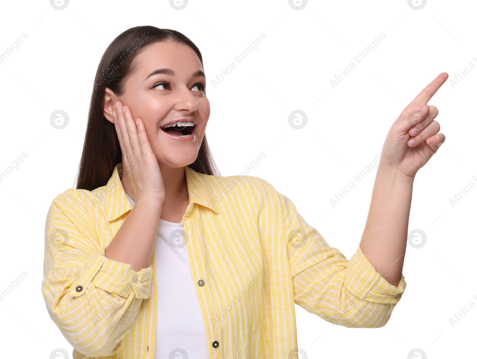 Photo of Smiling woman with dental braces pointing at something on white background