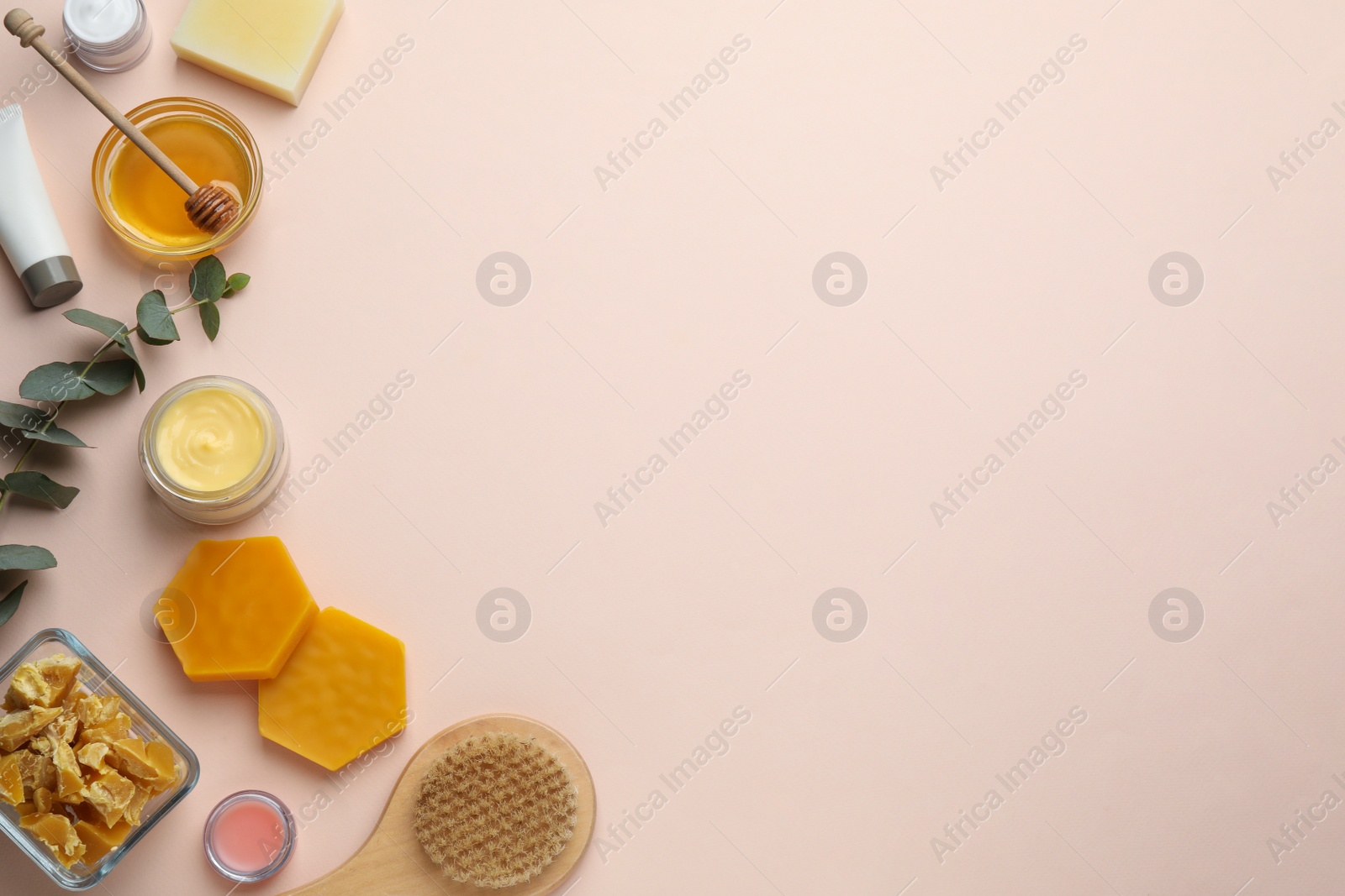 Photo of Flat lay composition with beeswax and cosmetic products on beige background. Space for text