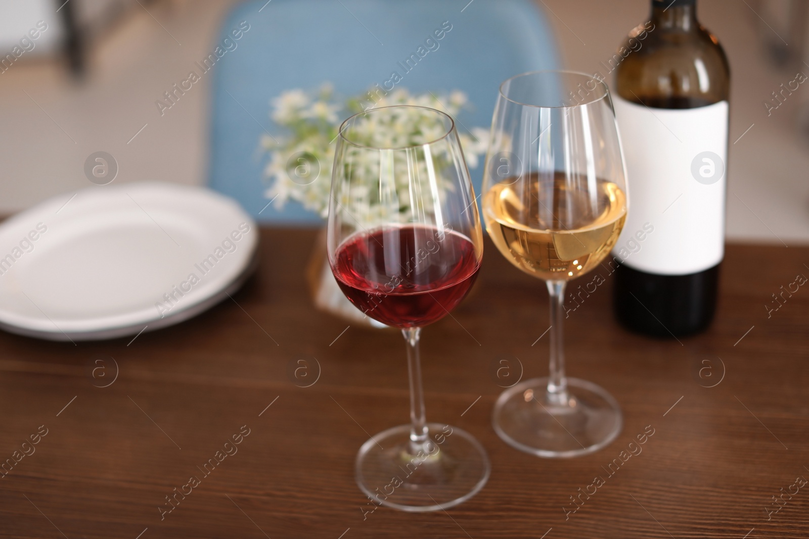 Photo of Glasses and bottle with tasty wine on table in restaurant