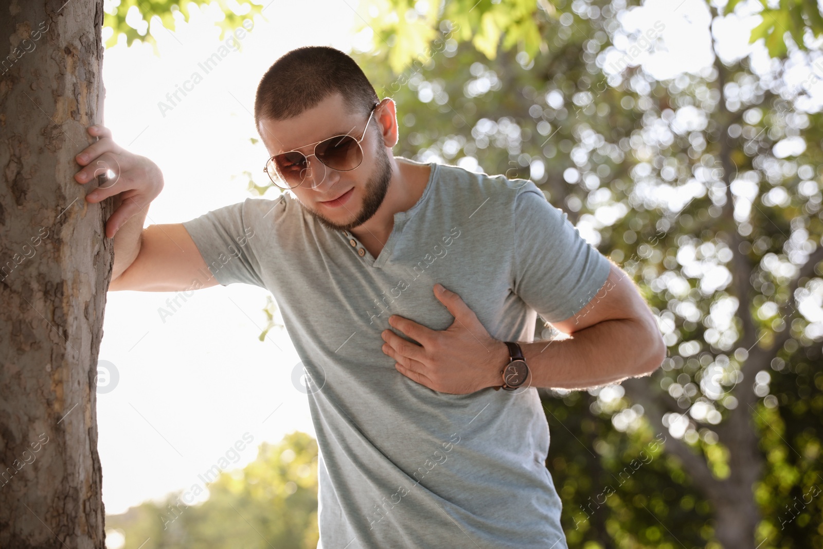 Photo of Man having heart attack near tree in park