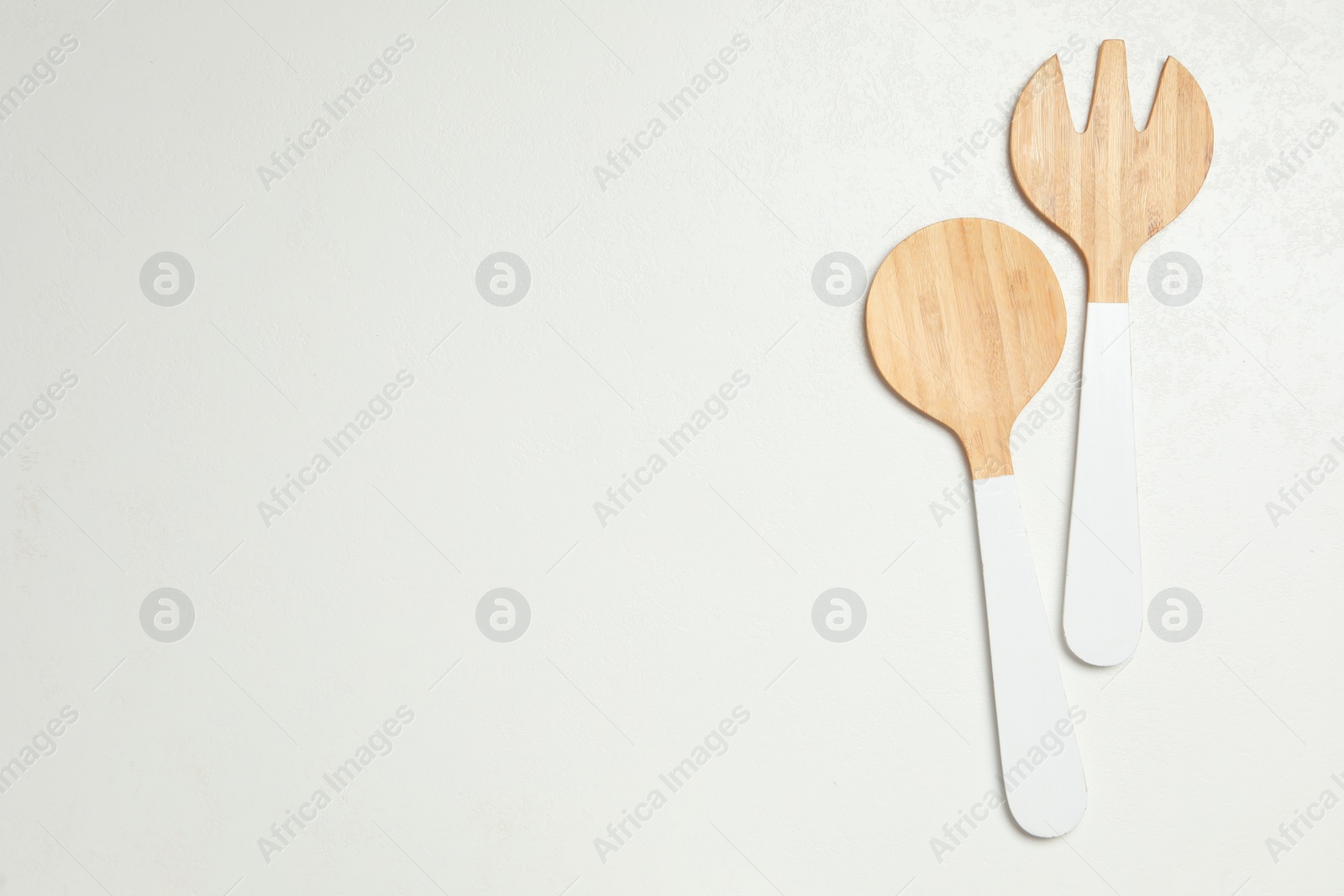 Photo of Wooden spoon and fork white background, flat lay with space for text. Cooking utensils