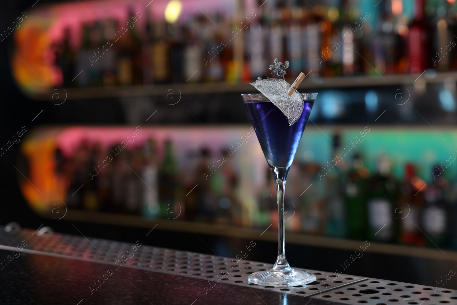 Photo of Fresh alcoholic cocktail in glass on bar counter. Space for text